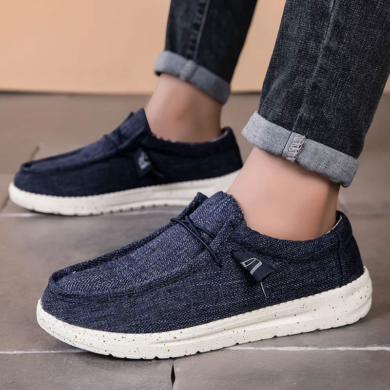 Donkerblauwe ademende casual instap loafers met witte spikkelzool, gedragen met opgerolde jeans.