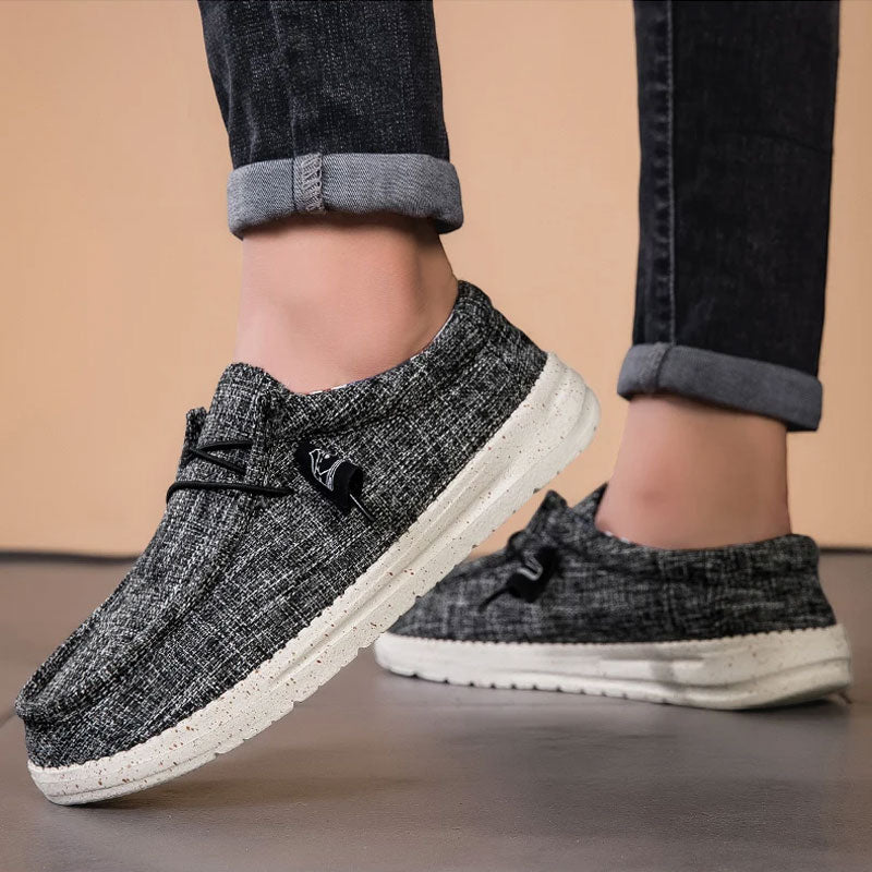 Donkergrijze ademende mesh instaploafers met witte zool en zwarte veters.
