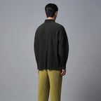Donkergroen geplooid poloshirt met lange mouwen en kraag, gedragen met olijfgroene plooibroek.