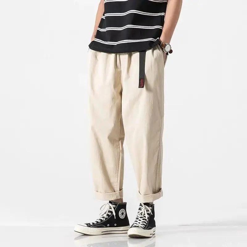 Beige katoenen wide leg cargo broek met elastische taille, riem en opgerolde enkels.