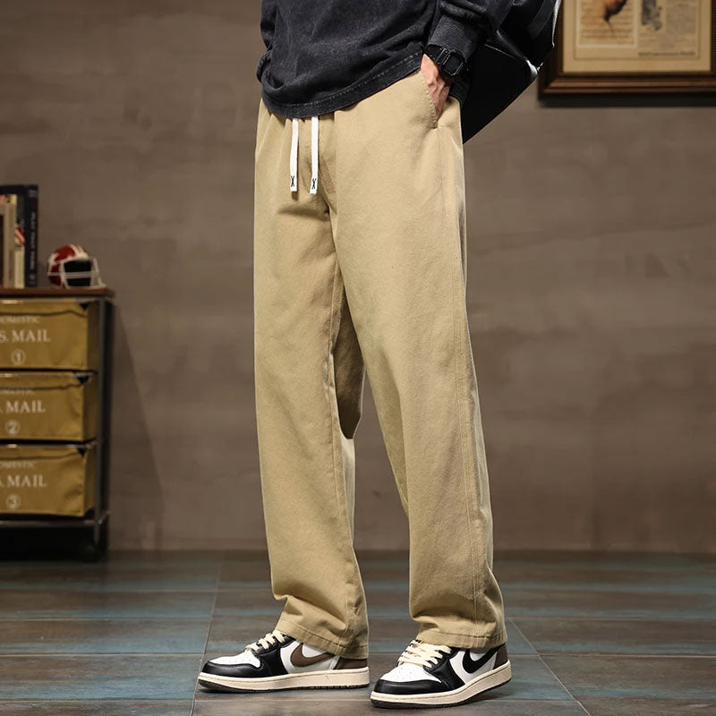 Losse, rechte beige katoenen cargo jogger broek met wijde pijpen en witte trekkoorden.