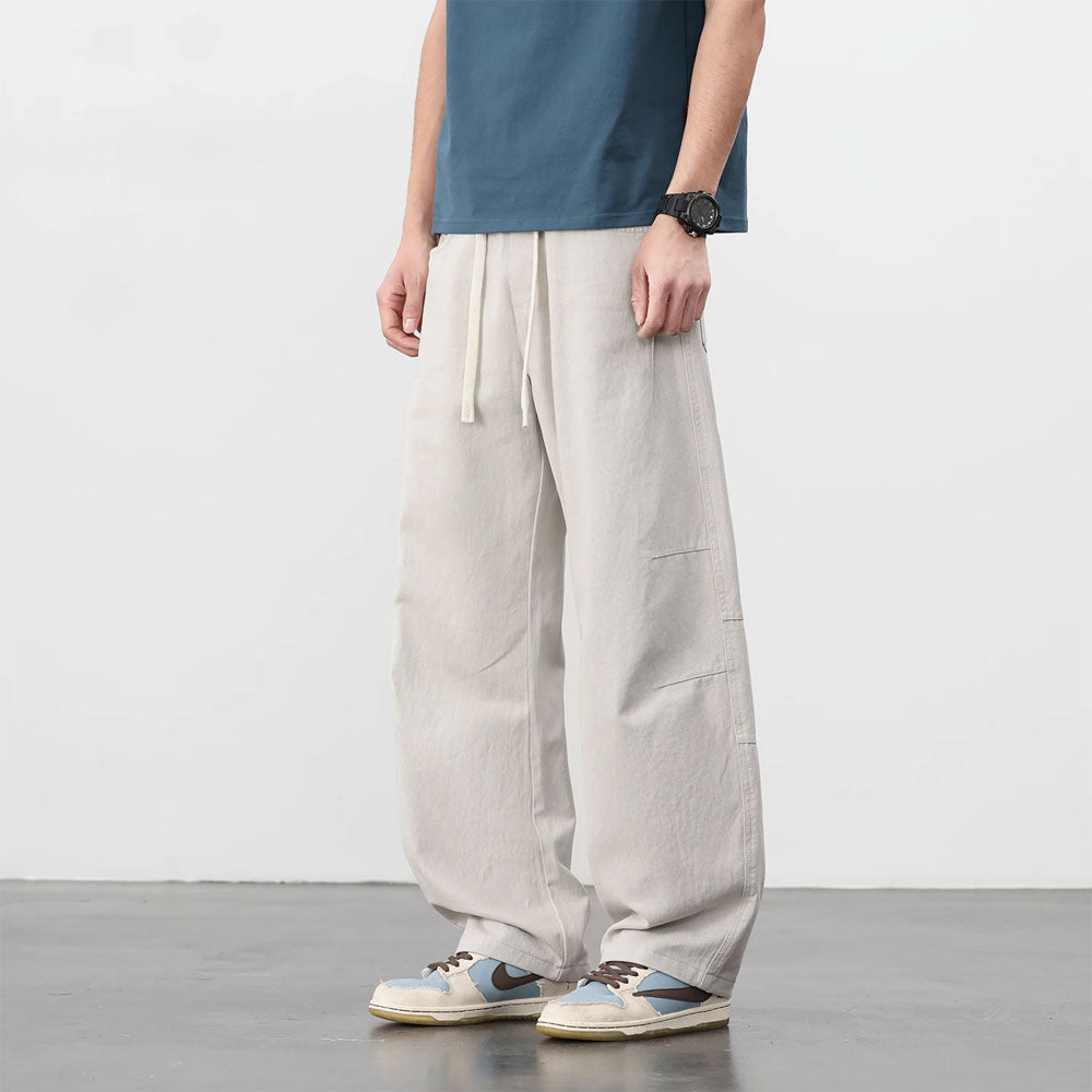 Lichte katoenen workwear broek met losse pasvorm, trekkoord en knoopsluiting.