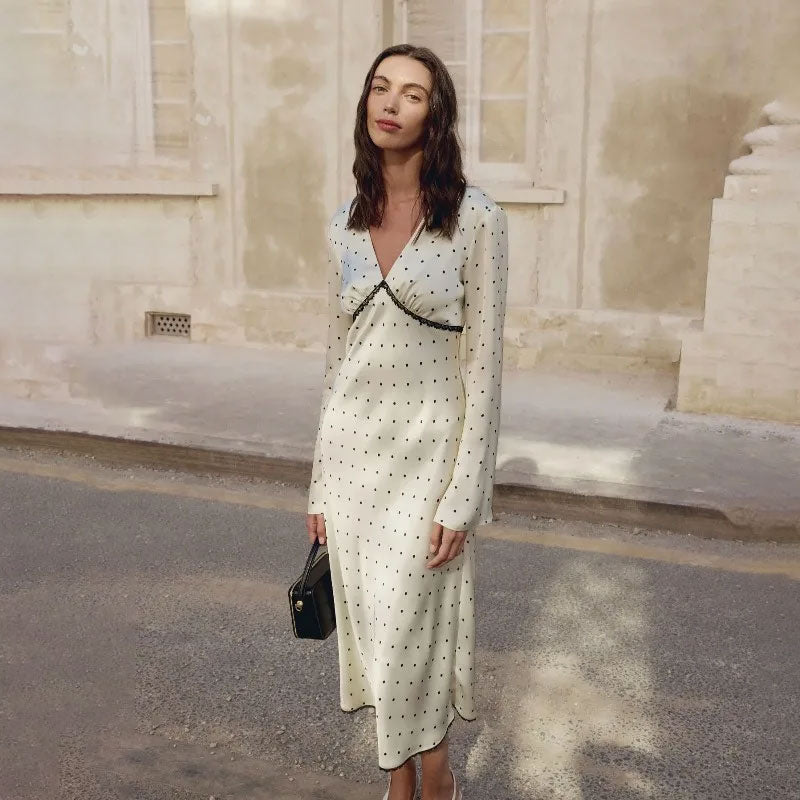 Elegante satijnen maxi jurk met vintage stippenprint en kanten patchwork, gedragen door een model.