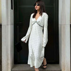 Elegante witte satijnen maxi jurk met zwarte stippenprint, V-hals en kanten patchwork.